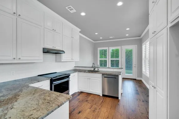 a kitchen with granite countertop white cabinets and white appliances