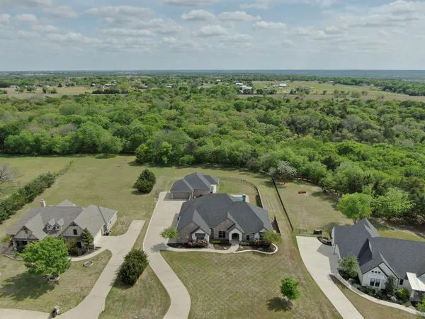 an aerial view of a house with a garden and lake view