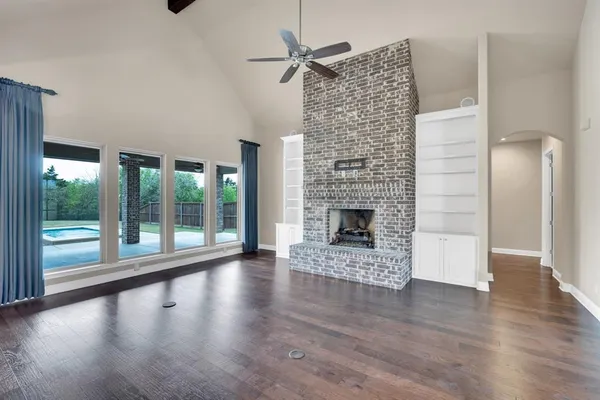 a view of empty room with wooden floor and fireplace