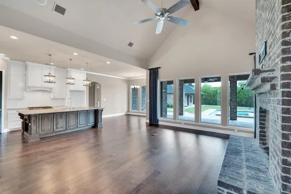 a view of an empty room with wooden floor and a large window