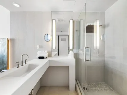 a bathroom with a double vanity sink mirror and shower
