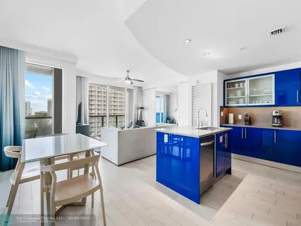 a large kitchen with stainless steel appliances granite countertop a large counter top and wooden floors