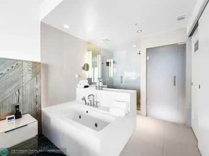 a en suite bathroom with a sink a tub and a mirror