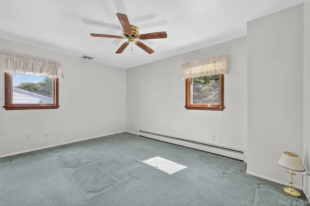 a view of a big room with wooden floor and windows