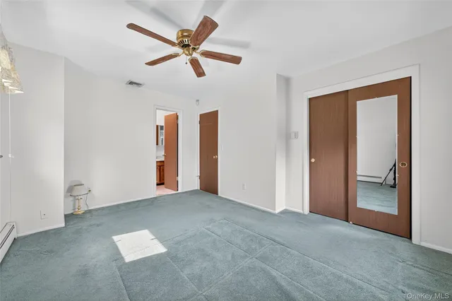 a view of a livingroom with a ceiling fan & windows