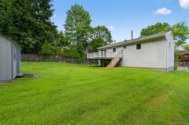 a view of a backyard with plants and large trees