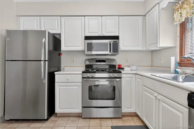 a kitchen with cabinets stainless steel appliances and a sink
