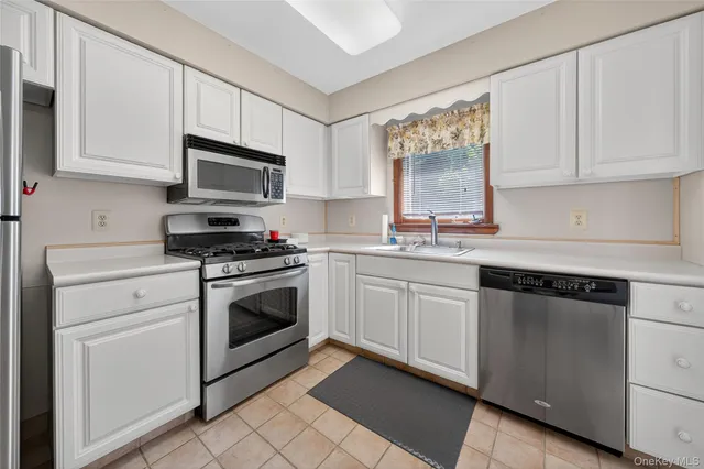 a kitchen with cabinets stainless steel appliances and a sink