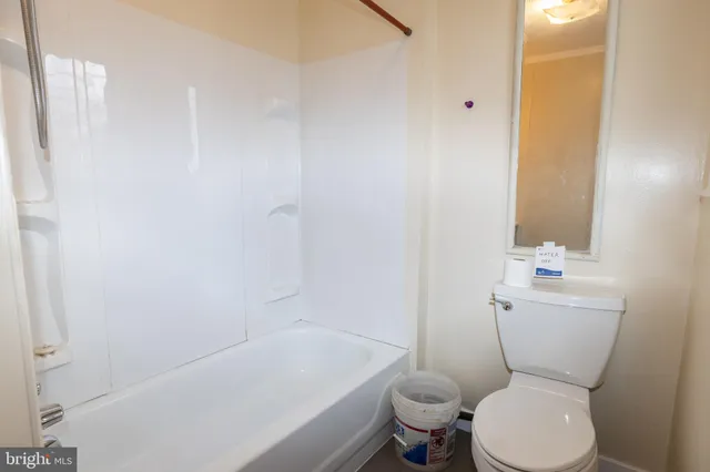 a white toilet sitting next to a white tub