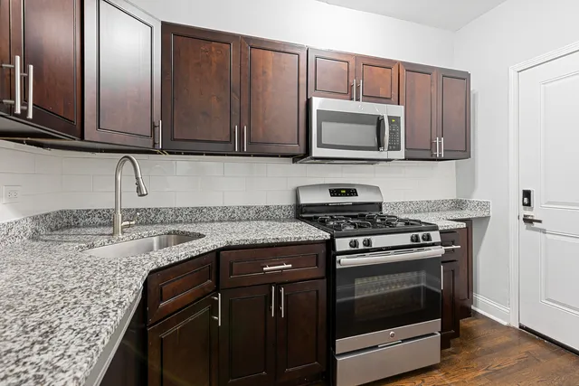 a kitchen with granite countertop wooden cabinets and stainless steel appliances