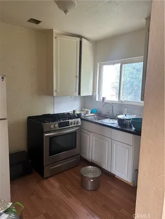 a kitchen with granite countertop a sink and a stove