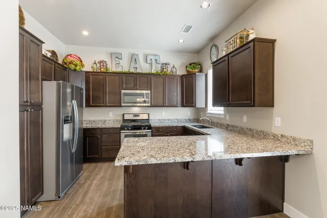 a kitchen with granite countertop a refrigerator stove and oven
