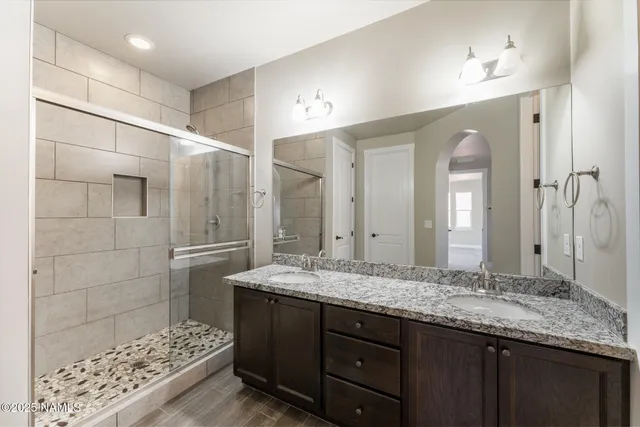 a bathroom with a granite countertop sink shower and a mirror