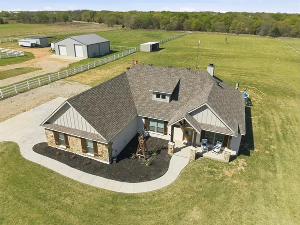 a aerial view of a house with a garden and lake view
