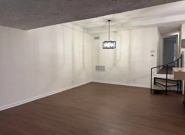 a view of a room with wooden floor and white walls