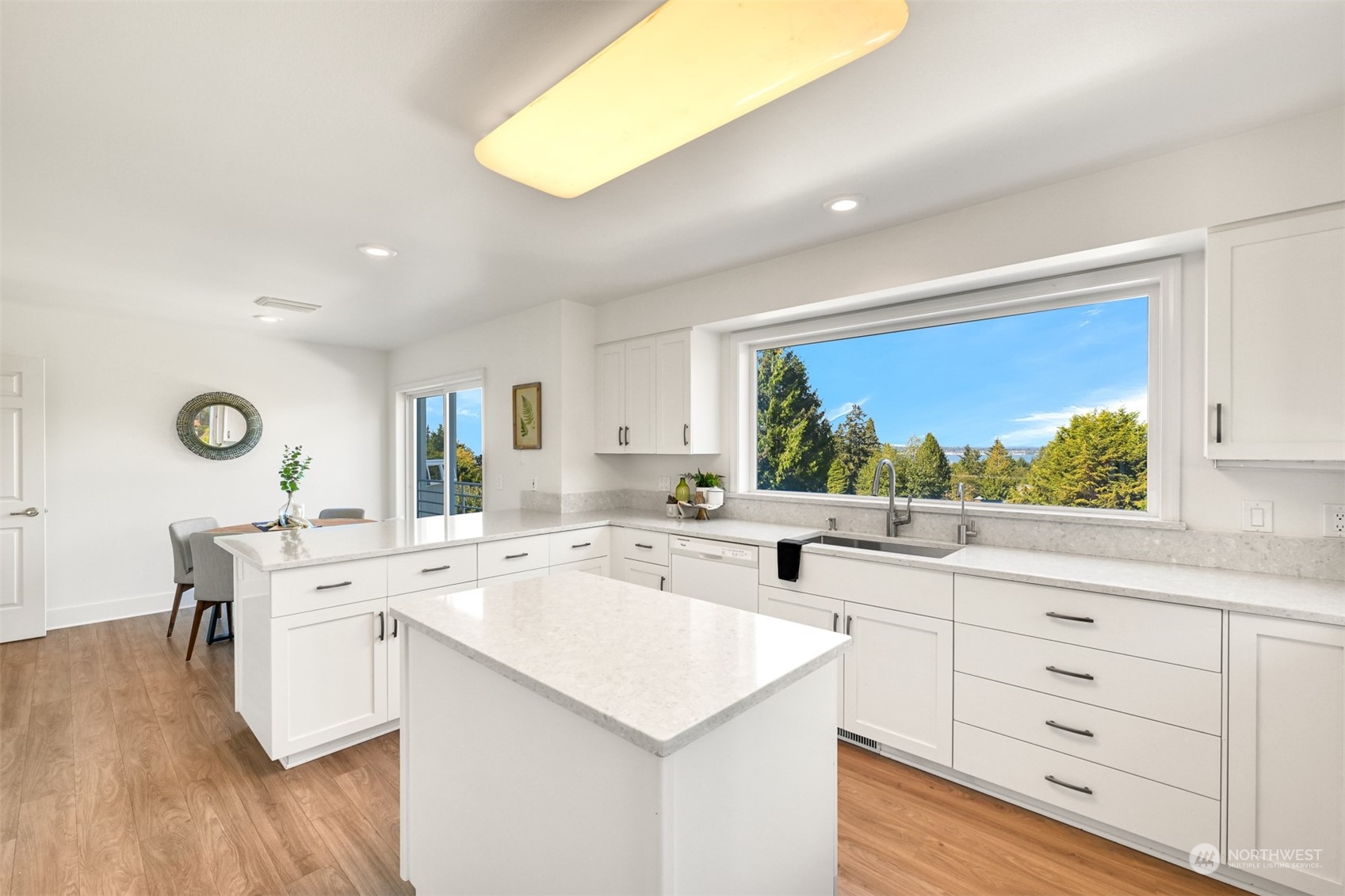215 Bayside Road Bellingham, WA 98225 - Photo 14 of 38 a open kitchen with a sink dishwasher stove and white cabinets with wooden floor