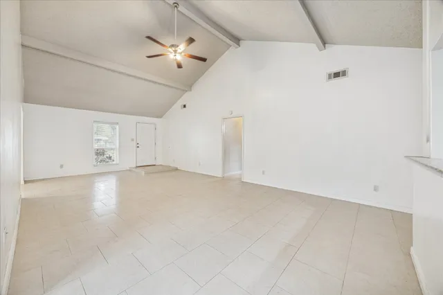 a view of a livingroom with a ceiling fan and entryway