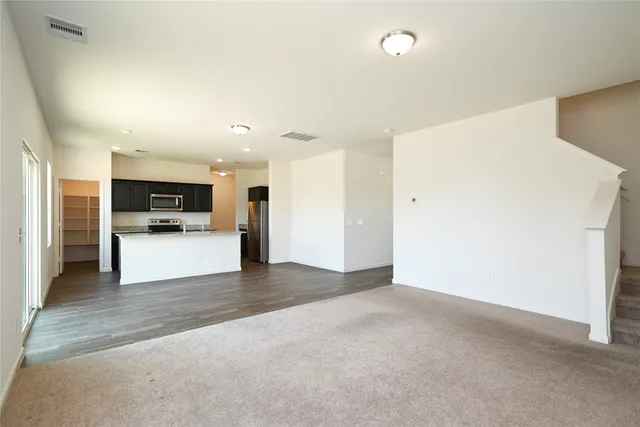 a view of kitchen with refrigerator stove microwave and white cabinets