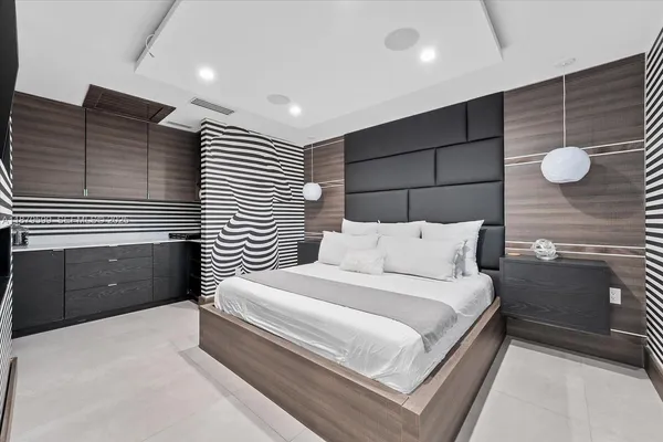 a spacious bedroom with a bed and a painting on the wall