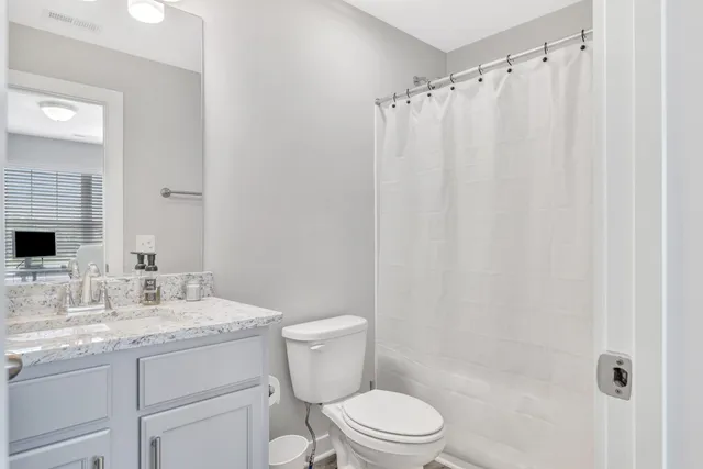 a bathroom with a granite countertop sink toilet and shower