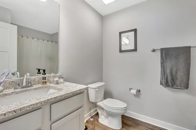 a bathroom with a granite countertop toilet sink and mirror