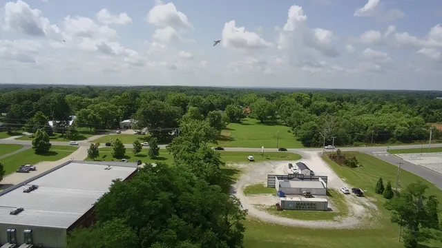 an aerial view of a city with lots of residential buildings green landscape and ocean view