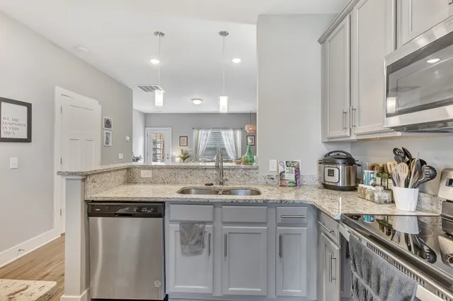 a kitchen with stainless steel appliances granite countertop a sink stove and cabinets