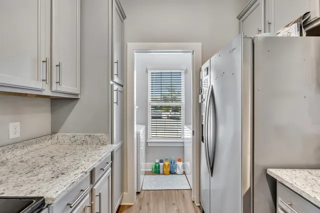 a kitchen with granite countertop a refrigerator and a sink