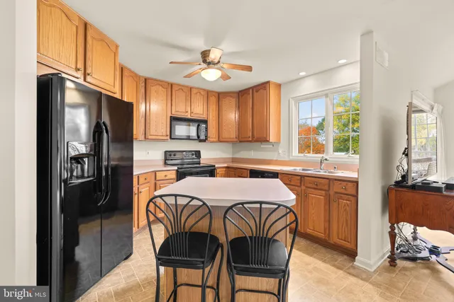 a kitchen with granite countertop wooden cabinets and a stove top oven