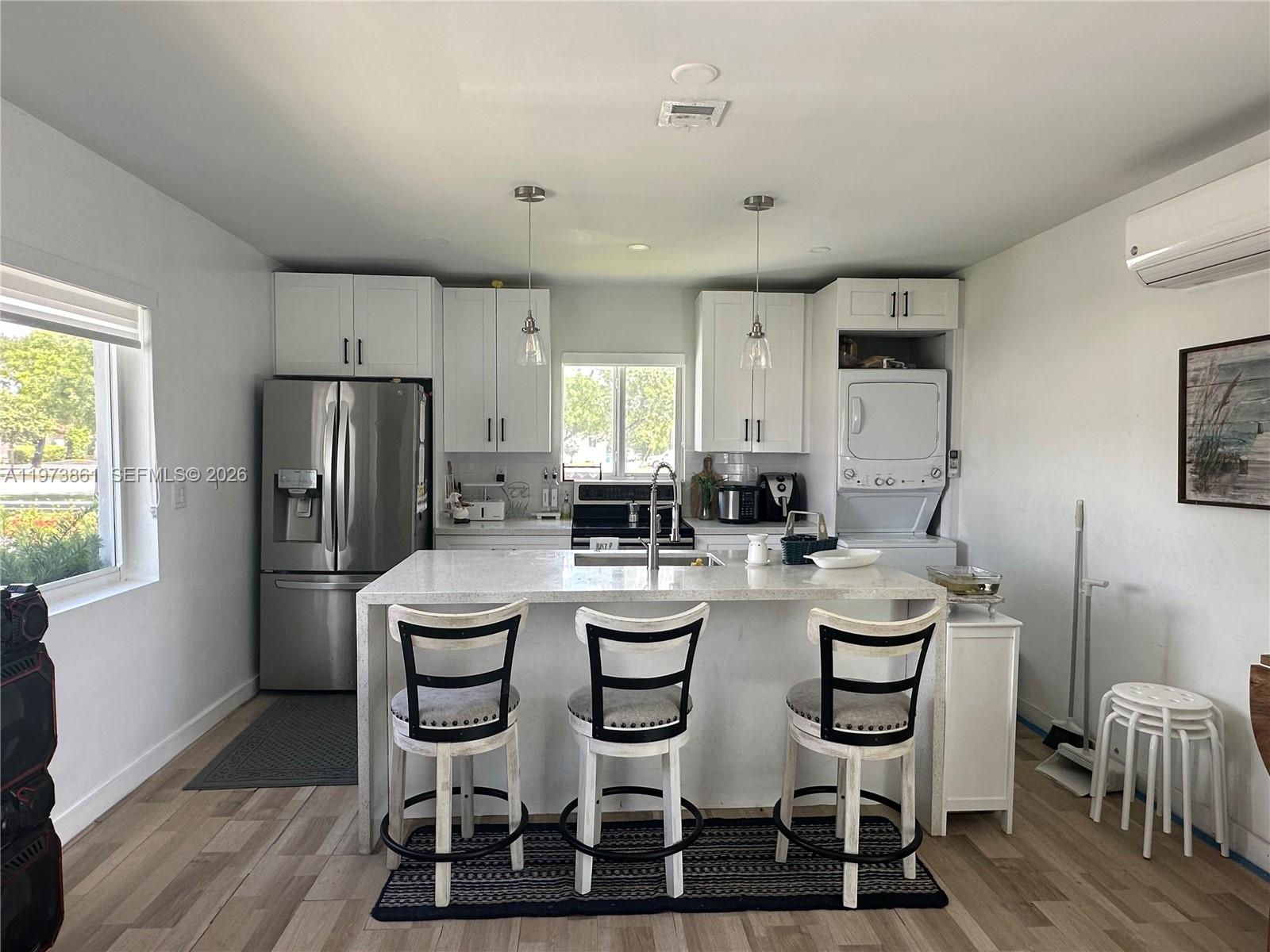 2401 Southwest 83rd Avenue Miami, FL 33155 - Photo 9 of 21 a kitchen with a dining table chairs refrigerator and cabinets