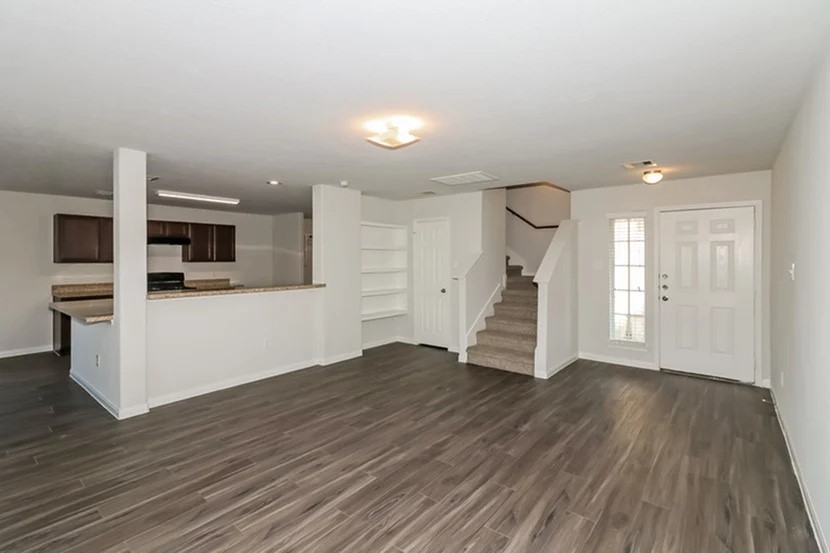 12615 Lady Slipper Road Houston, TX 77038 - Photo 3 of 13 a view of empty room with wooden floor and kitchen