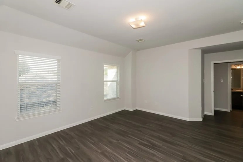 12615 Lady Slipper Road Houston, TX 77038 - Photo 6 of 13 an empty room with wooden floor and windows
