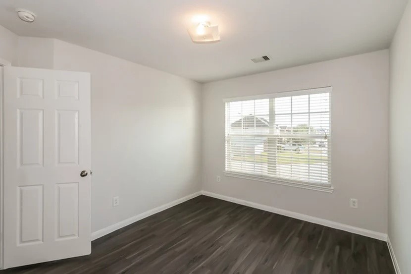 12615 Lady Slipper Road Houston, TX 77038 - Photo 7 of 13 a view of an empty room with wooden floor and a window