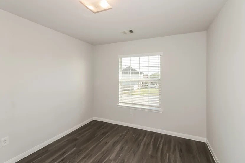 12615 Lady Slipper Road Houston, TX 77038 - Photo 8 of 13 an empty room with wooden floor and windows