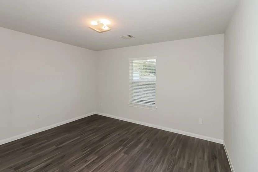 12615 Lady Slipper Road Houston, TX 77038 - Photo 9 of 13 a view of an empty room with wooden floor and a window