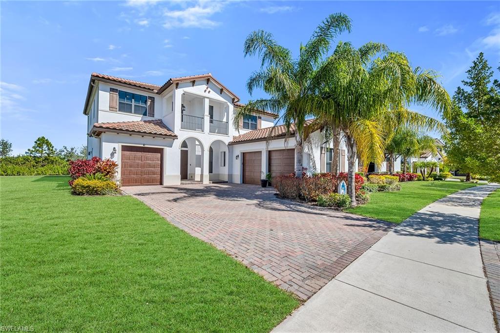 a front view of a house with a garden and palm trees