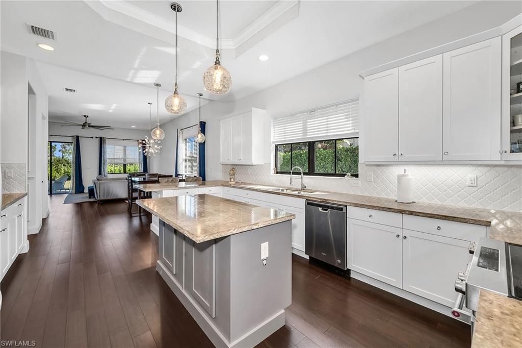 5344 Chandler Way Ave Maria, FL 34142 - Photo 11 of 47 a kitchen with stainless steel appliances granite countertop a sink a stove and a wooden floors