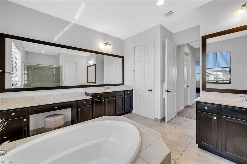 5344 Chandler Way Ave Maria, FL 34142 - Photo 29 of 47 a spacious bathroom with a granite countertop double vanity sink and a mirror