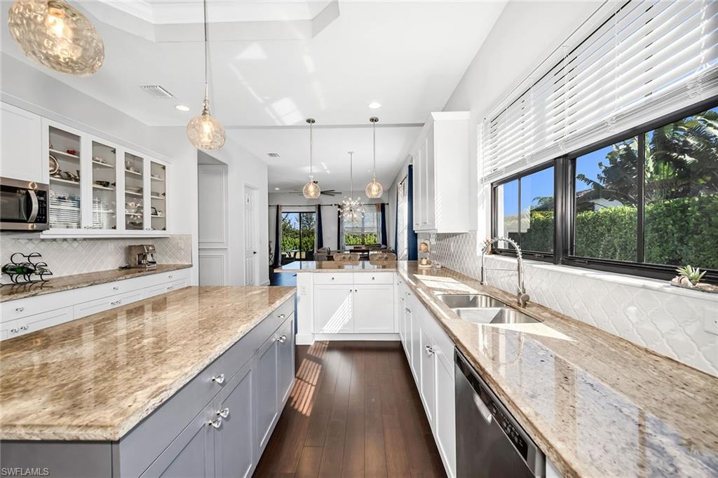 5344 Chandler Way Ave Maria, FL 34142 - Photo 3 of 47 a large kitchen with kitchen island a large window a sink and stainless steel appliances