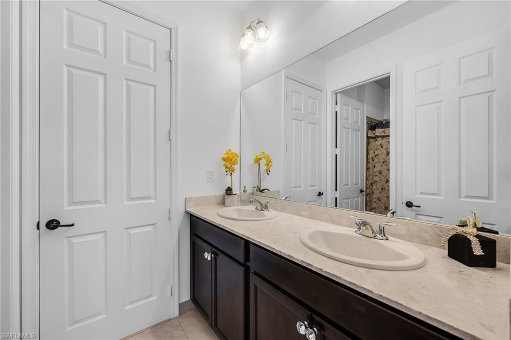 5344 Chandler Way Ave Maria, FL 34142 - Photo 33 of 47 a bathroom with a double vanity sink and a mirror