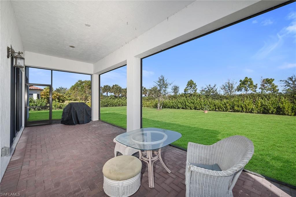 5344 Chandler Way Ave Maria, FL 34142 - Photo 37 of 47 a view of a patio with a table chairs and a yard