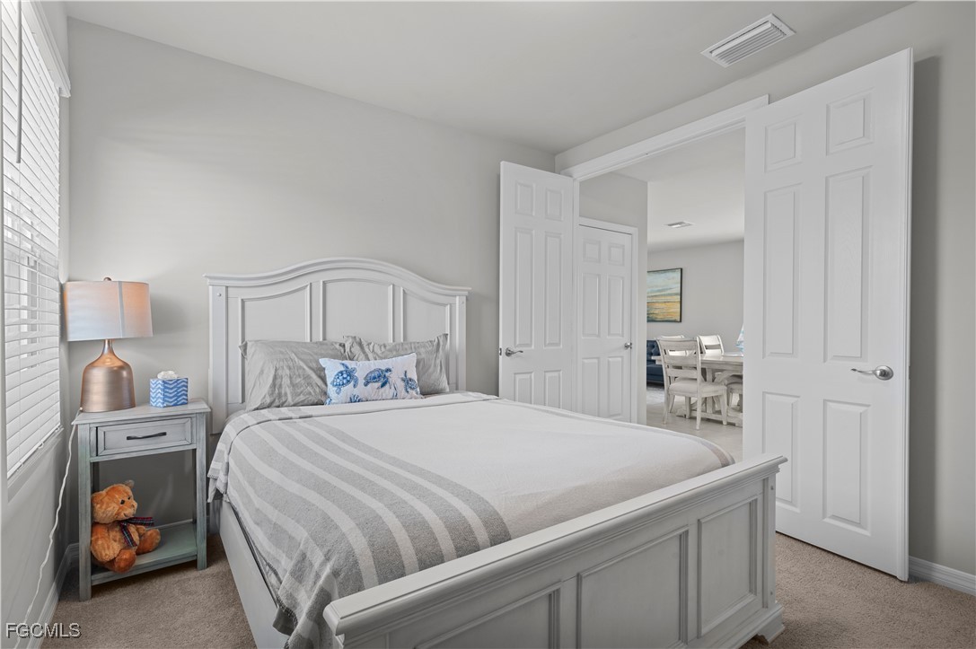 4320 Little Hickory Road Bonita Springs, FL 34134 - Photo 22 of 27 a bedroom with a bed and a lamp