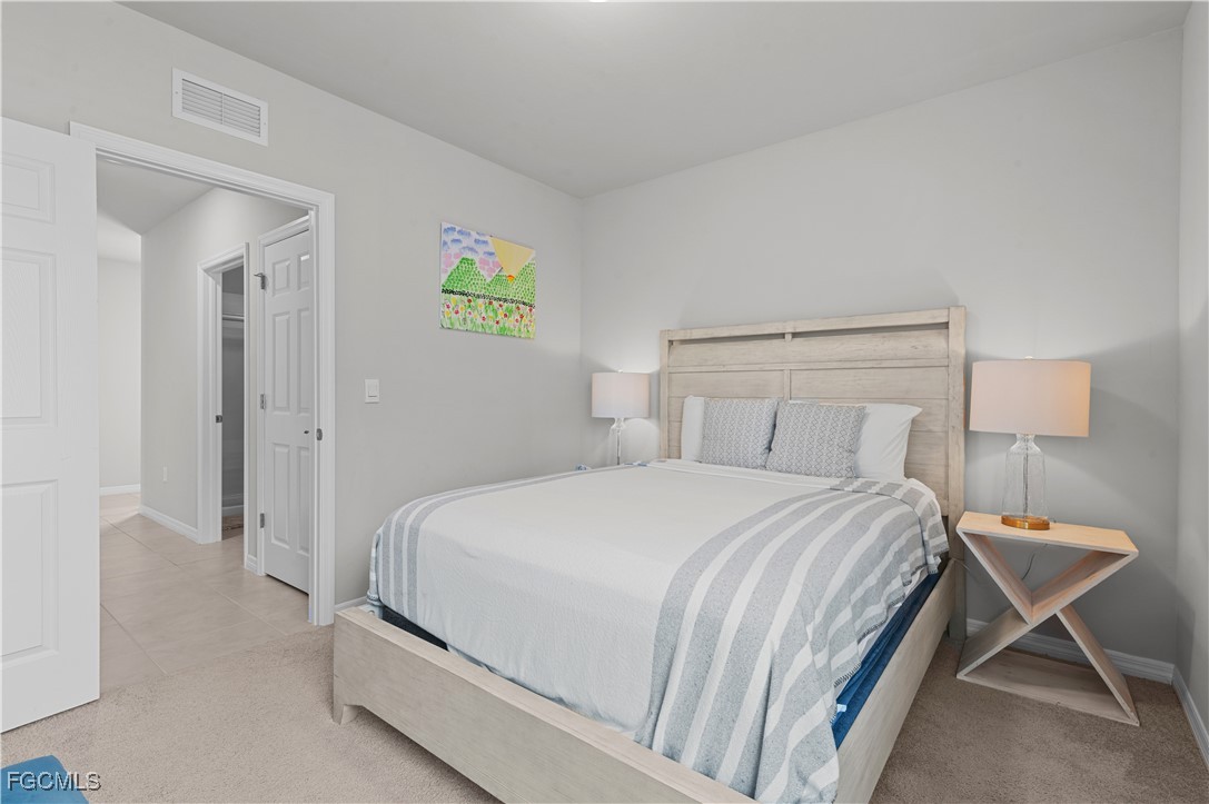 4320 Little Hickory Road Bonita Springs, FL 34134 - Photo 24 of 27 a bedroom with a bed and a lamp