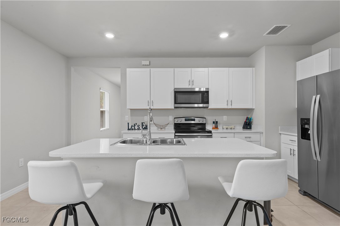 4320 Little Hickory Road Bonita Springs, FL 34134 - Photo 9 of 27 a kitchen with stainless steel appliances granite countertop a dining table chairs refrigerator and sink