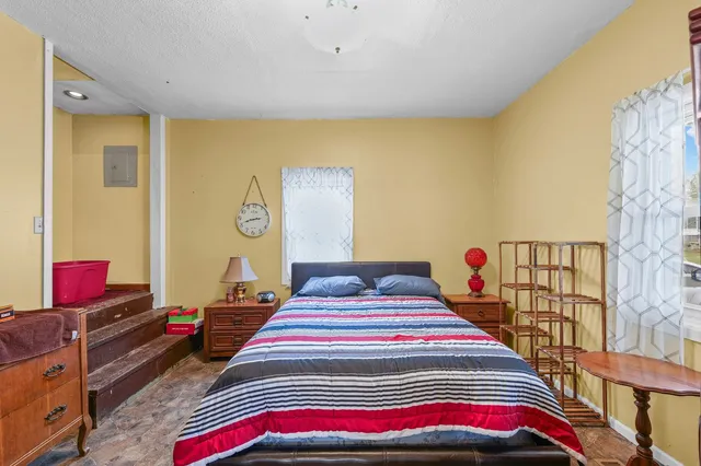 a bedroom with bed and wooden floor