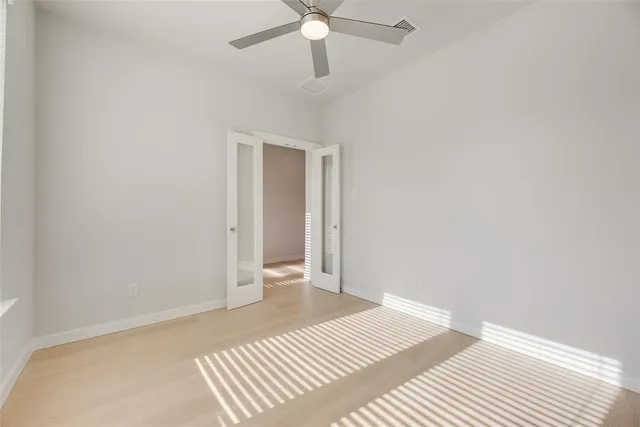 a view of a room with a ceiling fan and wooden floor