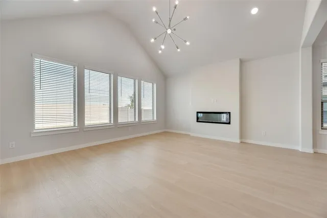 an empty room with windows and ceiling fan