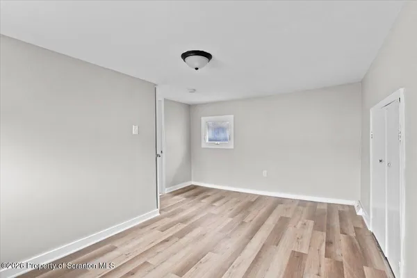 a view of room with wooden floor and fan