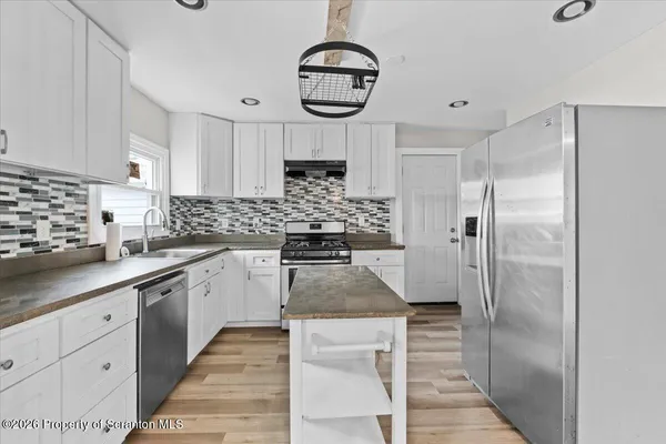 a kitchen with stainless steel appliances granite countertop a refrigerator and a stove