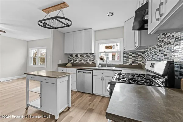 a kitchen with stainless steel appliances granite countertop a sink stove and cabinets